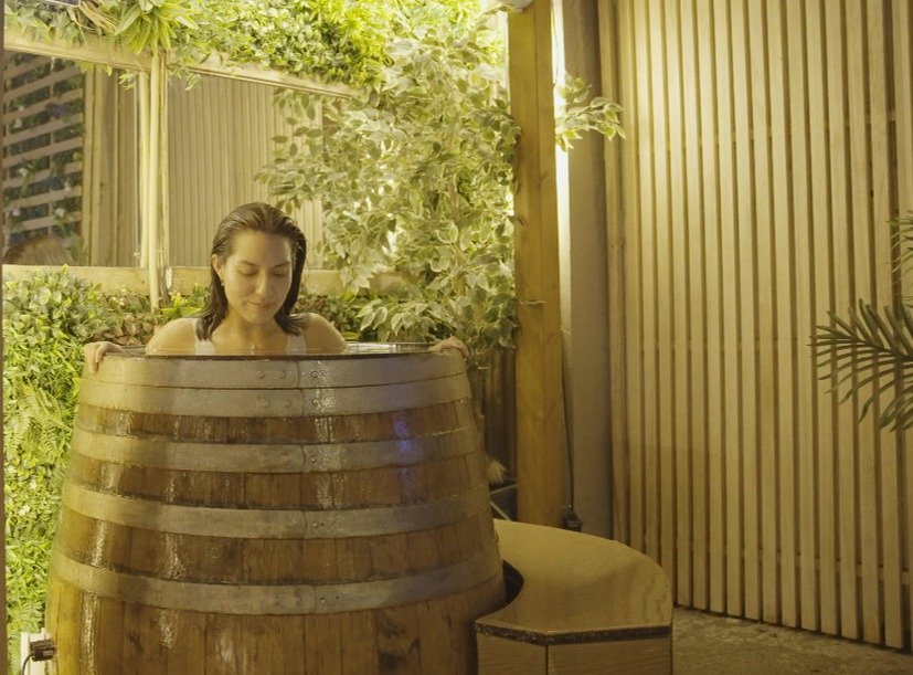 Woman relaxing in barrel ice bath